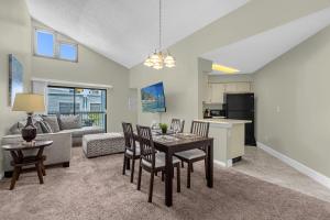 Una cocina y una sala de estar con mesa y sillas. en Modern Cozy 2BR Condo Near Disney, en Orlando