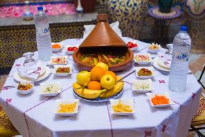 einen Tisch mit einem Buffet mit Speisen und Wasserflaschen in der Unterkunft Dar Fez Arabic in Fès