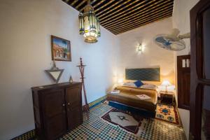 Schlafzimmer mit einem Bett und einem Kronleuchter in der Unterkunft Dar Fez Arabic in Fès