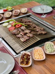 a grill with meat and vegetables on a wooden table at Süleyman Bey Konak in Safranbolu