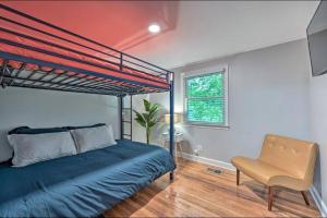um quarto com uma cama azul e uma cadeira em Entire bungalow hosted by Medina em Winston-Salem