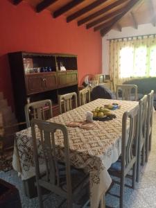 un comedor con una mesa con sillas y fruta. en casa con piscina, alojamiento hasta 12 personas en Asunción
