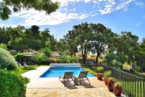 un patio trasero con piscina, sillas y árboles en Pirilampo, en Monchique