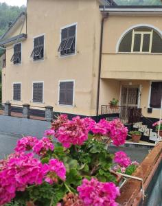ein Haus mit rosa Blumen davor in der Unterkunft La Casa Di Edy in Borzonasca