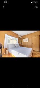 a bedroom with a large white bed with a window at Bonel Guest House in Tomisato