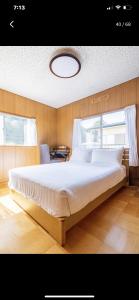 a bedroom with a large bed with a window at Bonel Guest House in Tomisato