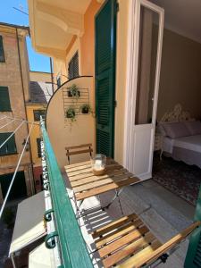 a balcony with a wooden table and a green door at Appartamento Nonna Lidia in Chiavari