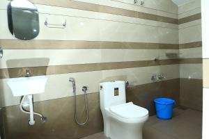 een badkamer met een toilet, een wastafel en een spiegel bij Bliss Homestay Munroe Island in Munroe Island