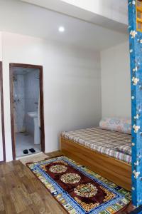 a bedroom with a bed and a rug on the floor at newa home in Pātan +5 photos