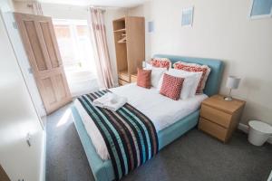 a bedroom with a blue bed with pillows and a window at Pheasant lodge - Balmaha 3 bed in Glasgow