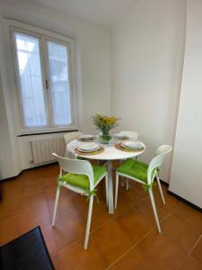 uma mesa branca com duas cadeiras verdes e uma mesa em Appartamento Nonna Lidia em Chiavari