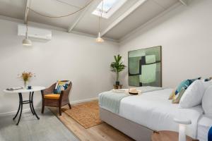 a bedroom with a bed and a table and a couch at Neighbourgood Franschhoek in Franschhoek