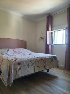 a bedroom with a bed with a floral bedspread at Casa Nuestro Sueño in Oria +47 photos