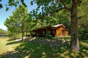 une cabane en rondins dans un champ avec un arbre dans l'établissement Domaine La Faix, Gite la Forestière, à Saint-Plaisir