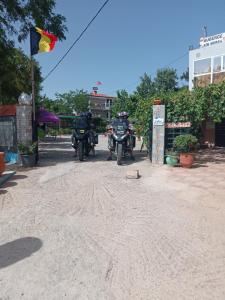 dos motocicletas estacionadas en un camino de tierra con una bandera en Motel Ain Mersa, en Ifrane