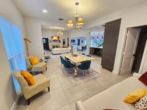 une salle à manger et un salon avec une table et des chaises dans l'établissement Beachside Bliss Pool Retreat Half mile to Beach, à Hollywood
