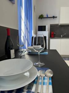 een tafel met een bord en wijnglazen erop bij feelgood in Trieste