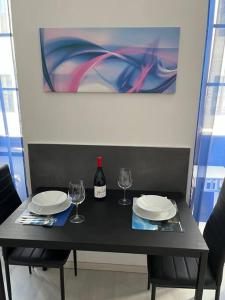 een zwarte tafel met twee borden en wijnglazen bij feelgood in Trieste