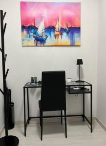 un bureau avec une chaise et un tableau mural dans l'établissement feelgood, à Trieste
