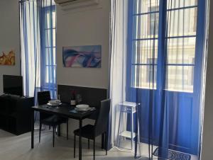 een eetkamer met een tafel en blauwe gordijnen bij feelgood in Trieste