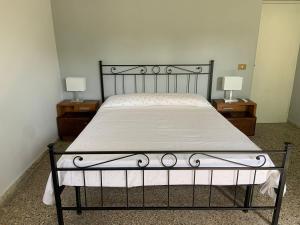 アンツィオにあるVilla Stellaの金属製のフレーム付きベッド、2つのナイトスタンド