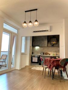 uma cozinha e sala de jantar com mesa e cadeiras em Lanada Apartment Skopje em Skopje