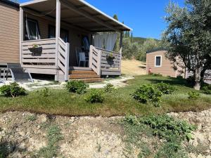 une maison avec une terrasse couverte munie d'une chaise. dans l'établissement Podere Cortesi Agriturismo Molinaccio, à Santa Luce