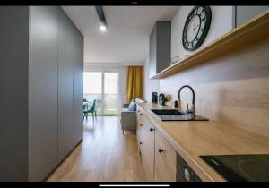 eine Küche mit einem Waschbecken und einer Uhr an der Wand in der Unterkunft Apartament Green 4Styles z miejscem postojowym w garażu podziemnym in Toruń