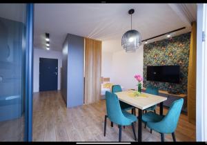 ein Esszimmer mit einem Tisch und blauen Stühlen in der Unterkunft Apartament Green 4Styles z miejscem postojowym w garażu podziemnym in Toruń