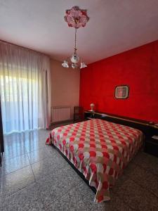1 dormitorio con paredes rojas y 1 cama grande en Casetta Vannella, en Valderice
