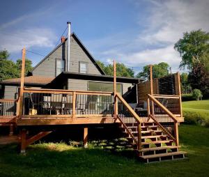 a house with a large wooden deck with stairs at Parkman Pad in Montague in Montague