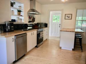 a kitchen with white cabinets and a wooden floor at Parkman Pad in Montague in Montague