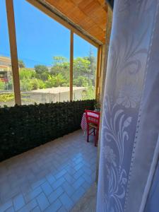 un patio con ventana, mesa y silla en Casetta Vannella, en Valderice