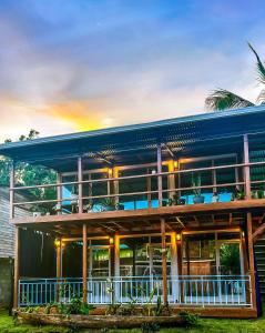 a house with a blue roof and a balcony at Suites Bocas del Toro in Carenero