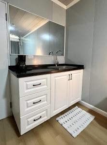 eine Küche mit weißen Schränken und einem Waschbecken in der Unterkunft Suites Bocas del Toro in Carenero