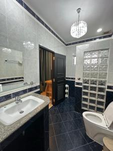 uma casa de banho com um lavatório, um WC e um espelho. em Wannashan pool villa em South Pattaya