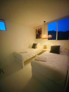 a room with two beds and a couch and a window at Espectacular Apartamento Jerusalema Villeta in Villeta