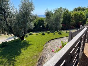 Glamping Tuscany - Podere Cortesi في سانتا لوتشي: حديقة خلفية بها سور وساحة بها زهور