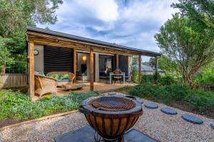 a backyard with a fire pit and a house at Treebia Self-catering - Loadshedding Free in Plettenberg Bay