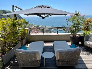 a patio with a table and chairs and an umbrella at Portopiccolo Designer Penthouse in Sistiana