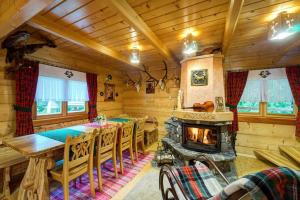 a dining room with a fireplace in a log cabin at Bacówka Polanki in Obidowa