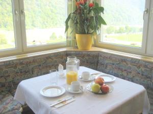 a table with a plate of fruit and a pitcher of orange juice at Pension Feiken in Wesenufer