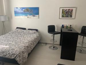a bedroom with a bed and a desk and two chairs at Apartment Vito in Vantaa