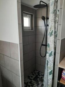 a shower with a shower curtain in a bathroom at Maison proche gare et commodités in Le Mans