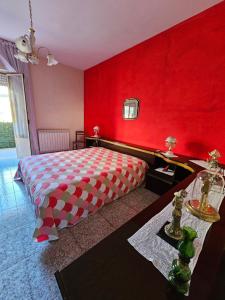 1 dormitorio rojo con 1 cama con pared roja en Casetta Vannella, en Valderice