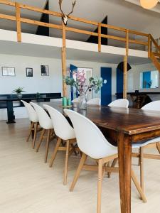 een eetkamer met een houten tafel en witte stoelen bij Country guesthouse in Gadstrup