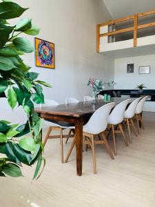 a dining room with a wooden table and white chairs at Country guesthouse in Gadstrup