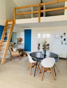 een eetkamer met een zwarte tafel en witte stoelen bij Country guesthouse in Gadstrup