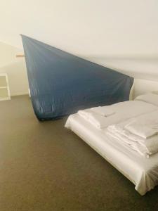 a bed with a blue sheet on it in a room at Country guesthouse in Gadstrup