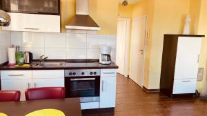 a kitchen with a sink and a stove top oven at Haus Am Strand in Breege